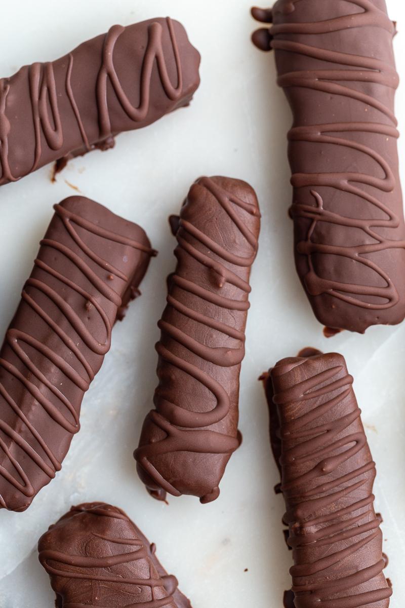 top down shot of from-scratch twix chocolate bars. There's extra chocolate drizzled on top of them in a swirled pattern