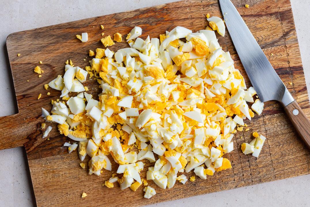 chopped up hard boiled eggs on a wood cutting board