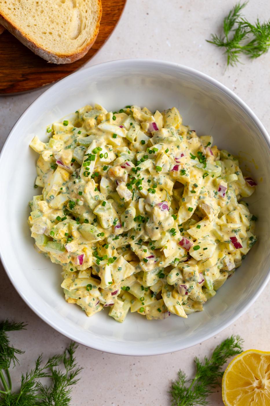 large bowl filled with from-scratch egg salad topped with chives