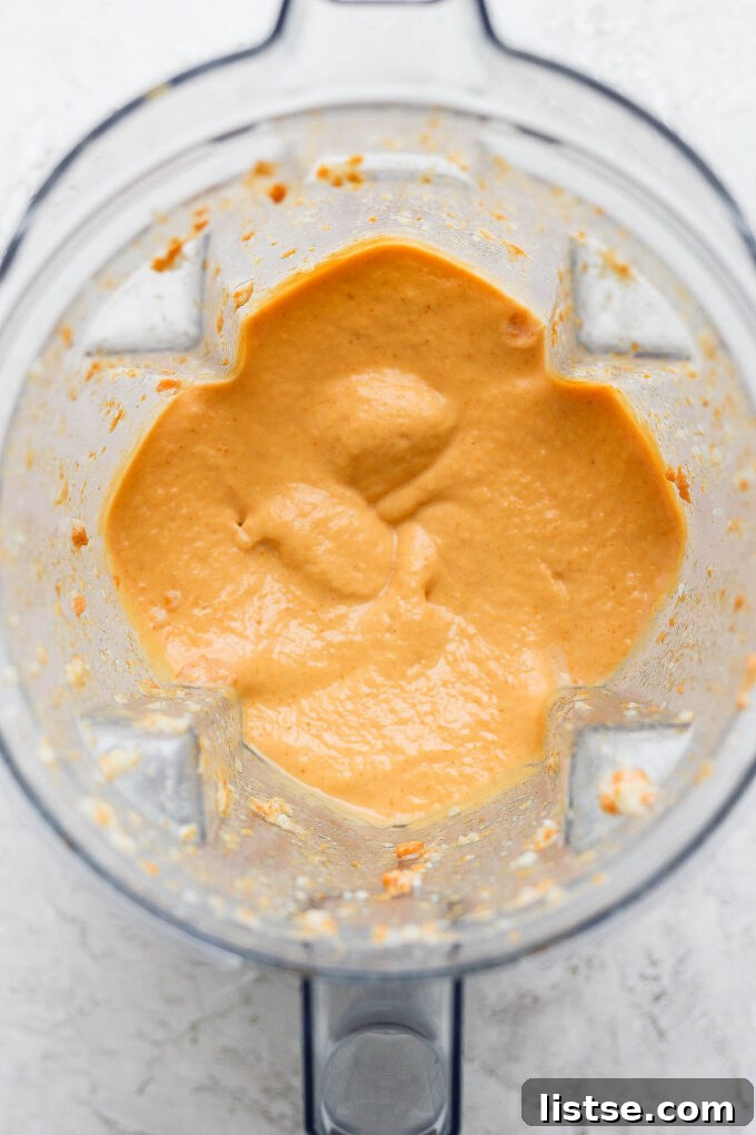 A perfectly blended orange smoothie in the blender jug, ready to be served.