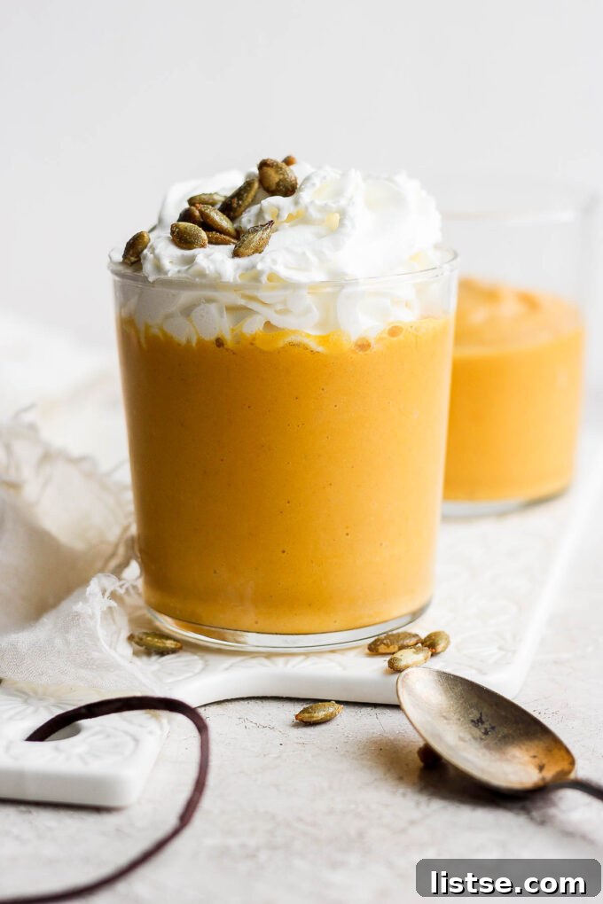 Orange smoothie topped with whipped cream, ready to be enjoyed.