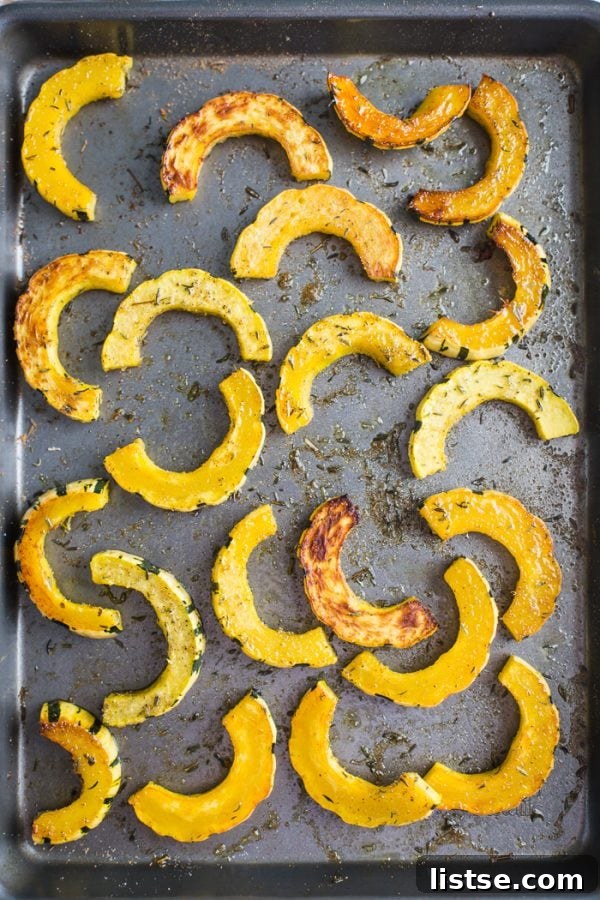 Sweet cinnamon roasted delicata squash on a baking sheet