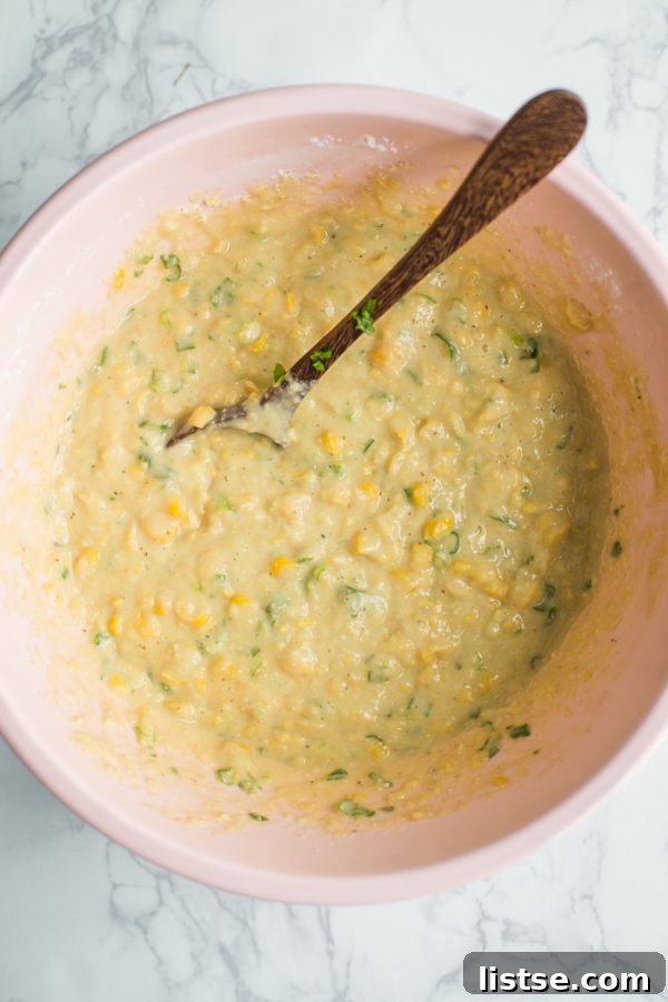 Mixing the batter for Vegan Corn Fritters in a large mixing bowl.
