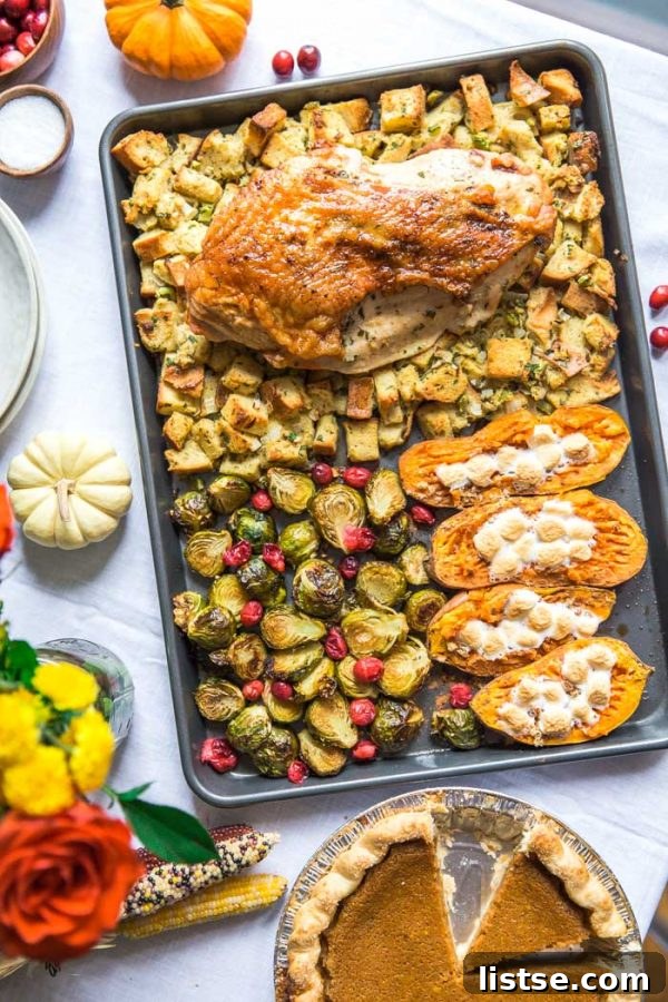 Sheet pan Thanksgiving dinner featuring turkey, stuffing, sweet potatoes, and brussels sprouts.