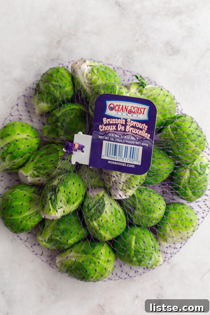 A bag of fresh Ocean Mist Farms Brussels sprouts in a purple mesh bag.