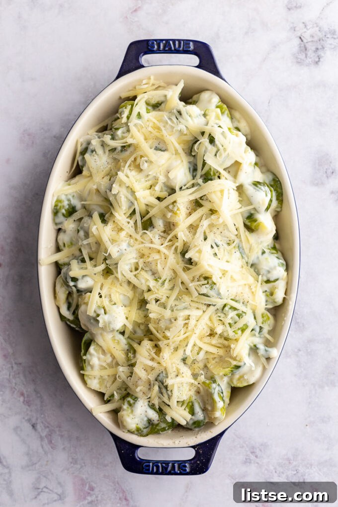 Close-up of baked cheesy Brussels sprouts au gratin, garnished with fresh herbs.