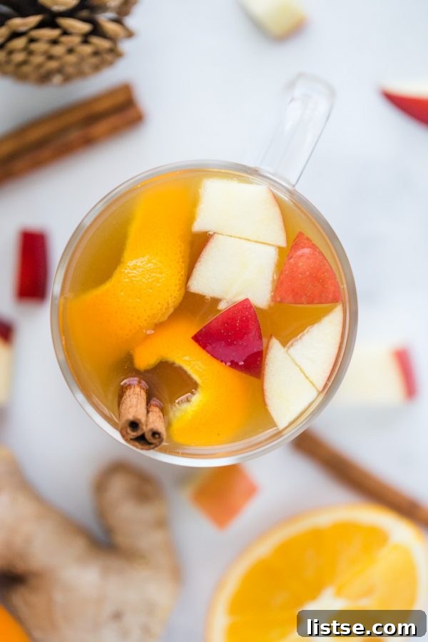Hot slow cooker mulled cider with cranberries and an orange slice garnish