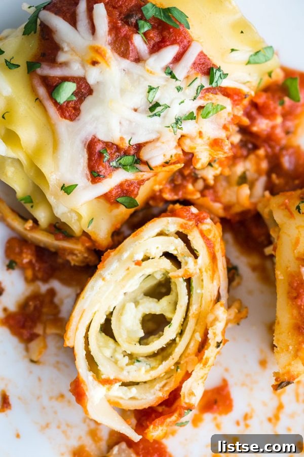 Close-up of baked Lasagna Roll Ups with melted cheese and sauce