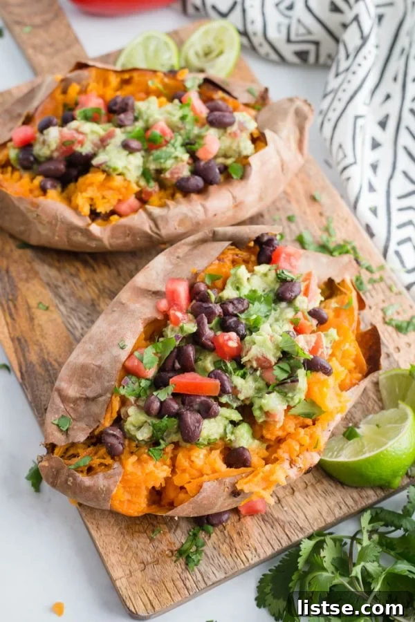 A beautifully presented Guacamole Stuffed Sweet Potato, showcasing the vibrant green guacamole, black beans, and fluffy sweet potato flesh.