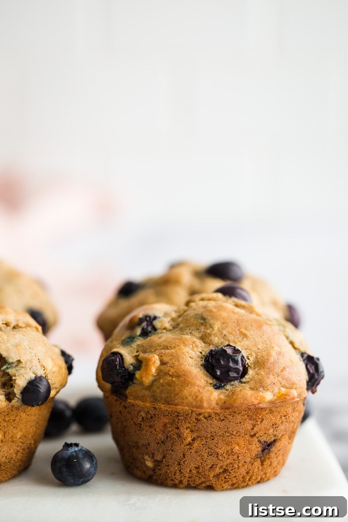 Delicious vegan blueberry muffins arranged beautifully on a marble board, highlighting their golden-brown tops and juicy blueberries.