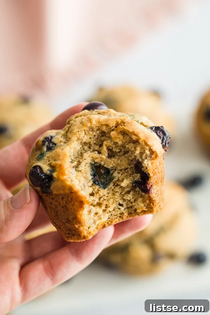 Close-up shot of fluffy vegan blueberry muffins, showcasing their soft interior and scattered blueberries.