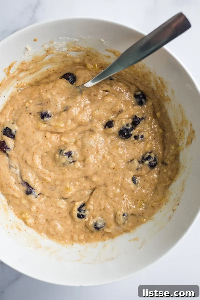 A large bowl filled with vegan blueberry muffin batter, ready for baking.