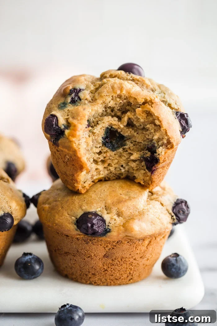 Stack of vegan blueberry muffins on a marble board, invitingly presented.