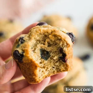 Close-up of a vegan blueberry muffin, highlighting its fluffy texture.