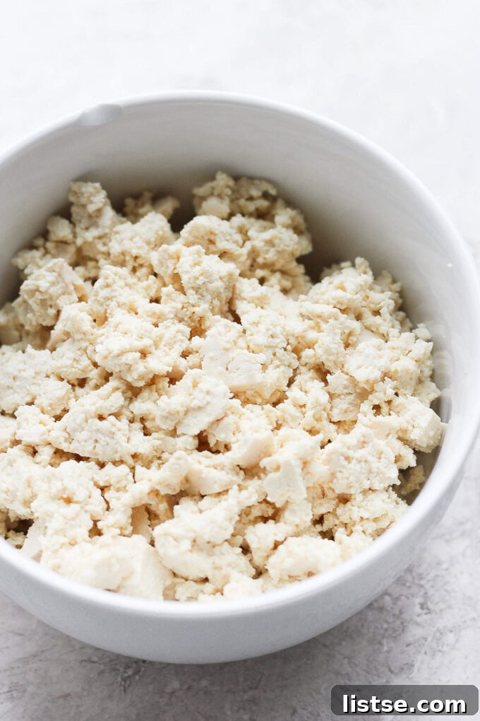 Effortless Tofu Taco Bliss 6 Close-up of a bowl filled with freshly crumbled firm tofu, ready to be seasoned for tacos, showcasing its textured consistency.