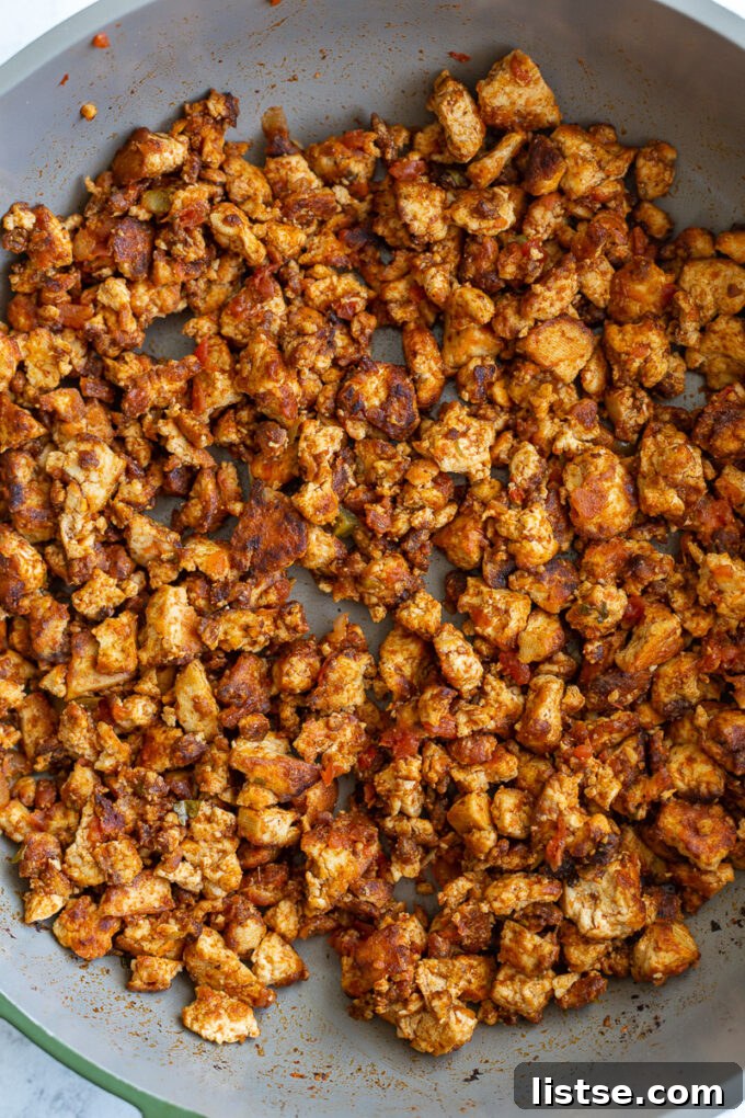 Effortless Tofu Taco Bliss 7 Golden-brown tofu crumbles sizzling in a non-stick skillet, expertly seasoned and developing crispy edges, ready for the next step in making vegan taco meat.