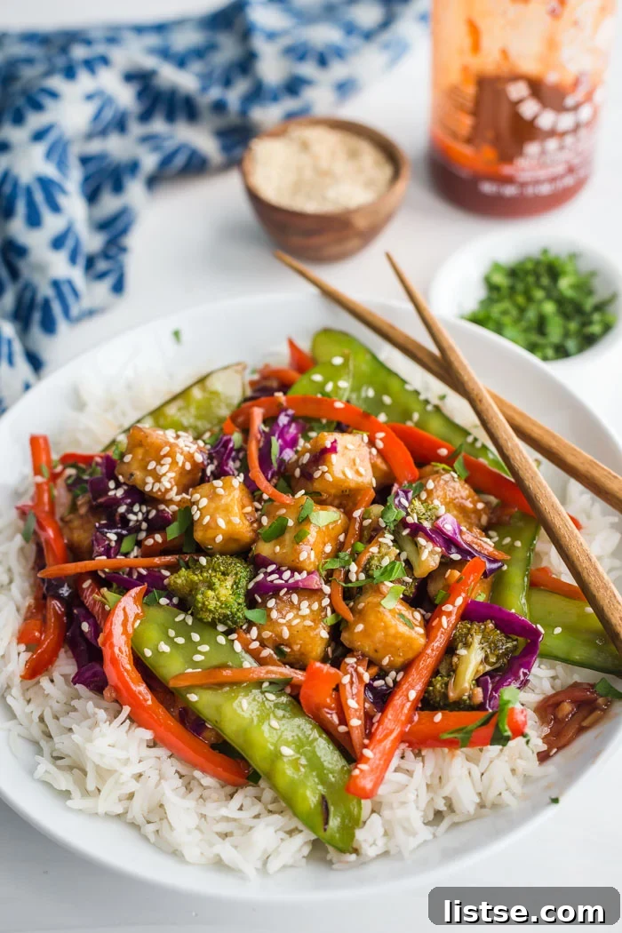 Crispy Tofu Stir Fry with vibrant vegetables on a white background, ready to be served.
