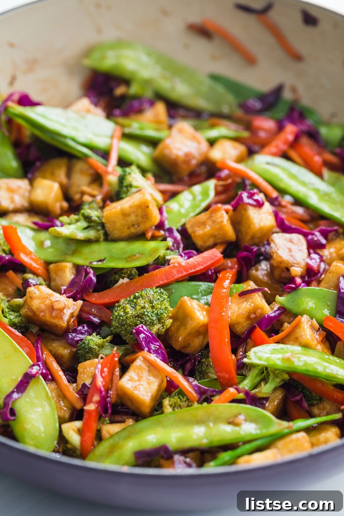 Close-up of golden brown crispy tofu pieces mixed with colorful stir-fried vegetables.