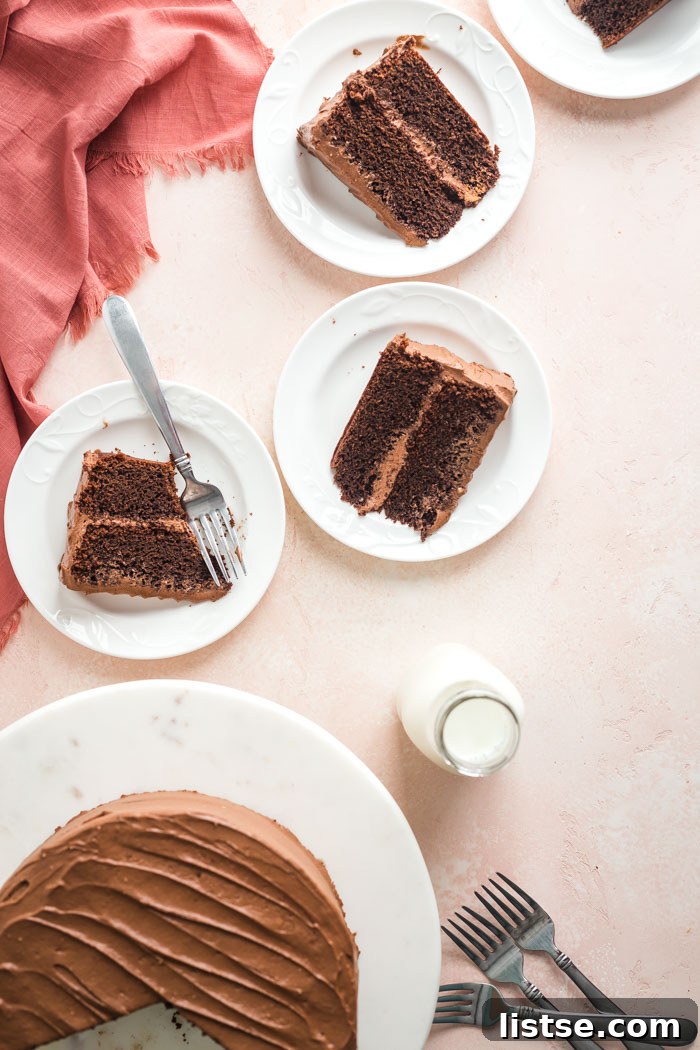 Velvet Vegan Chocolate Cake 4 Multiple slices of a beautifully frosted vegan chocolate cake displayed on white plates, showcasing its inviting appearance.