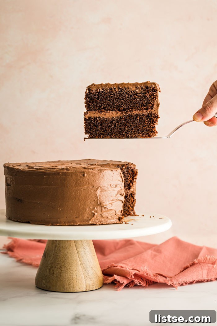 Velvet Vegan Chocolate Cake 8 A delightful slice of vegan chocolate cake artfully placed on a marble cake stand, highlighting its elegant presentation.