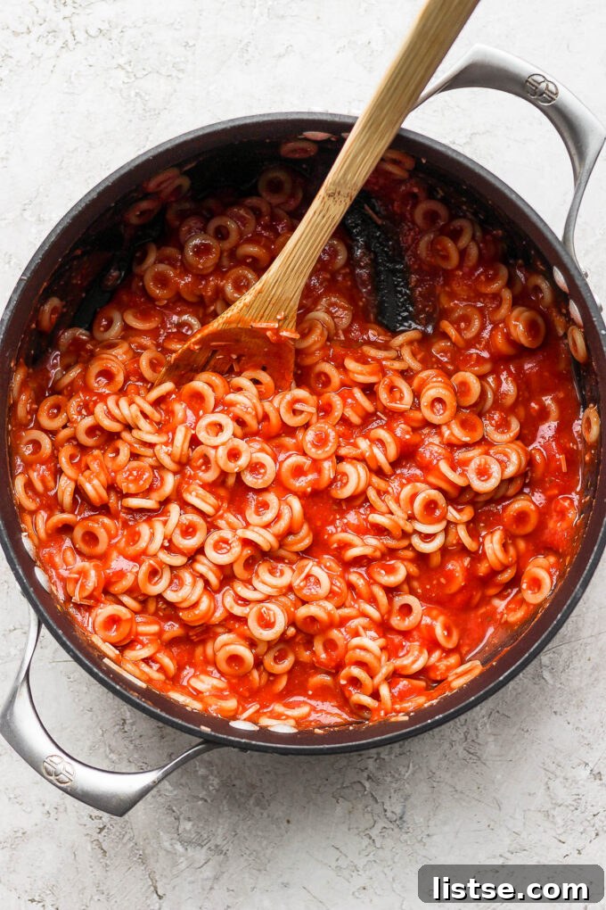 DIY Pasta Hoops 7 A close-up shot of the perfectly coated homemade spaghettios simmering gently in the pot, ready to be served.