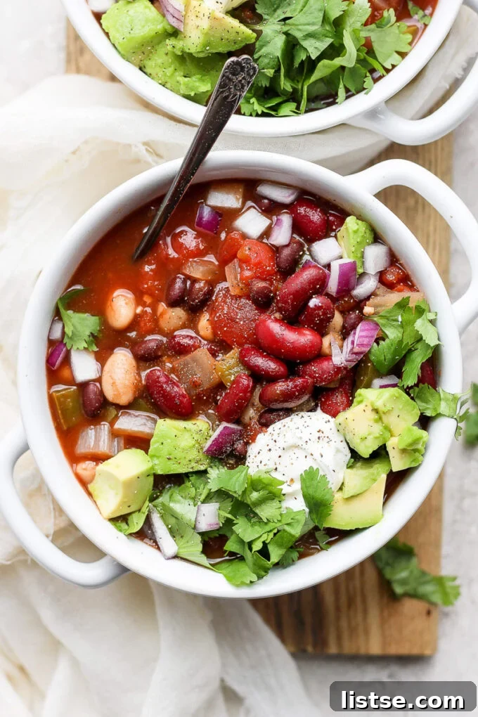 Hearty Slow Cooker Plant-Based Chili 2 vegan crockpot chili in a white bowl with a spoon