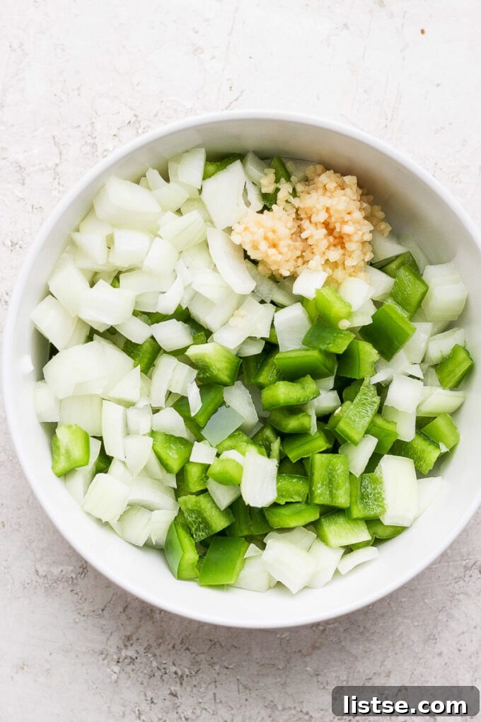 Hearty Slow Cooker Plant-Based Chili 4 diced onion and green bell pepper in a white bowl