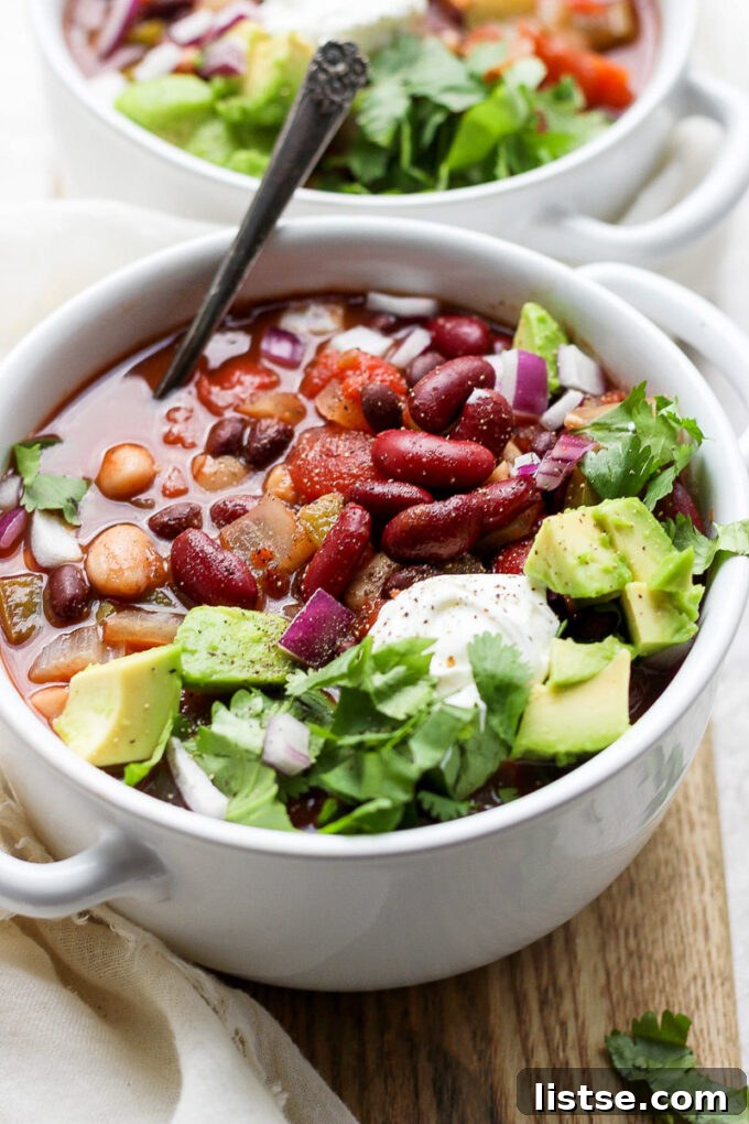 Hearty Slow Cooker Plant-Based Chili 7 bowl filled with vegan crockpot chili and topped with avocado and cilantro