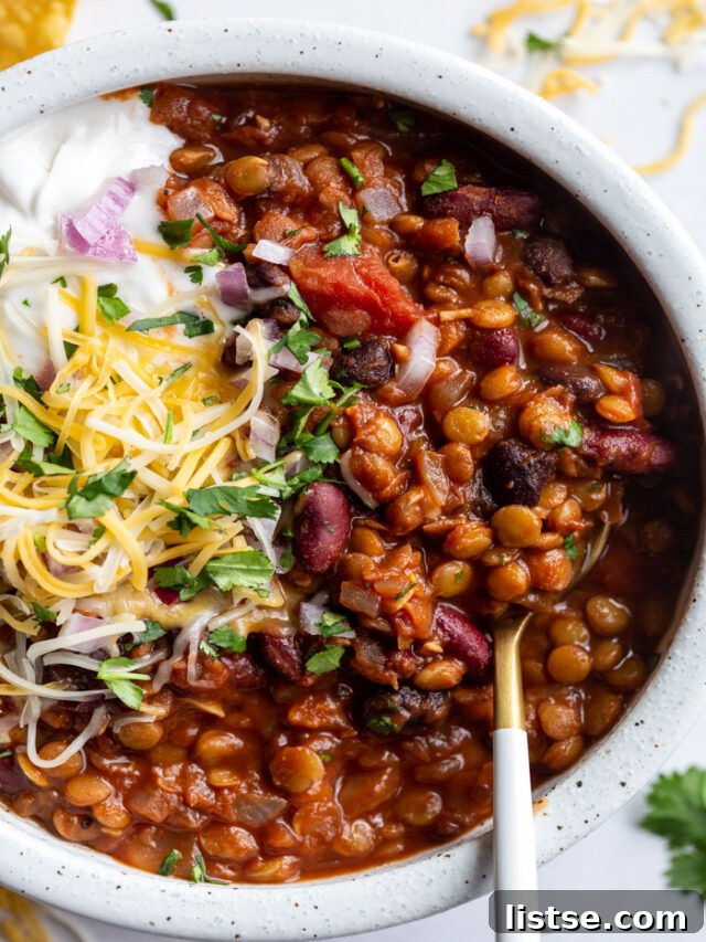 Hearty lentil chili, garnished with fresh herbs.