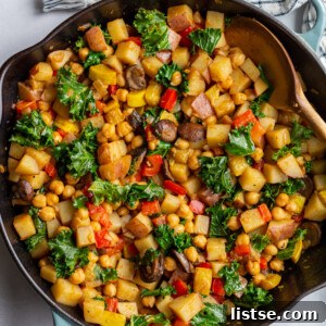 stirring vegan hash with a wooden spoon in a large skillet, showcasing the vibrant vegetables.