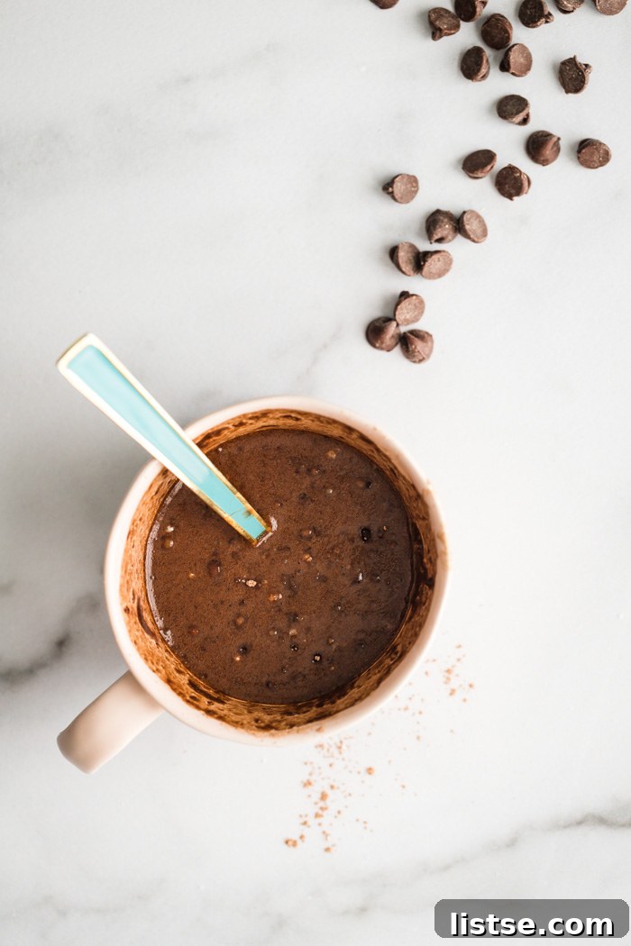 chocolate cake batter being mixed in a mug