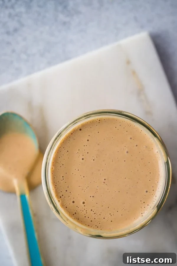 Beautifully textured peanut sauce resting on a marble board, ready for use.