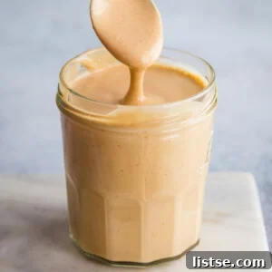 A small jar of freshly made peanut sauce, ready for serving.