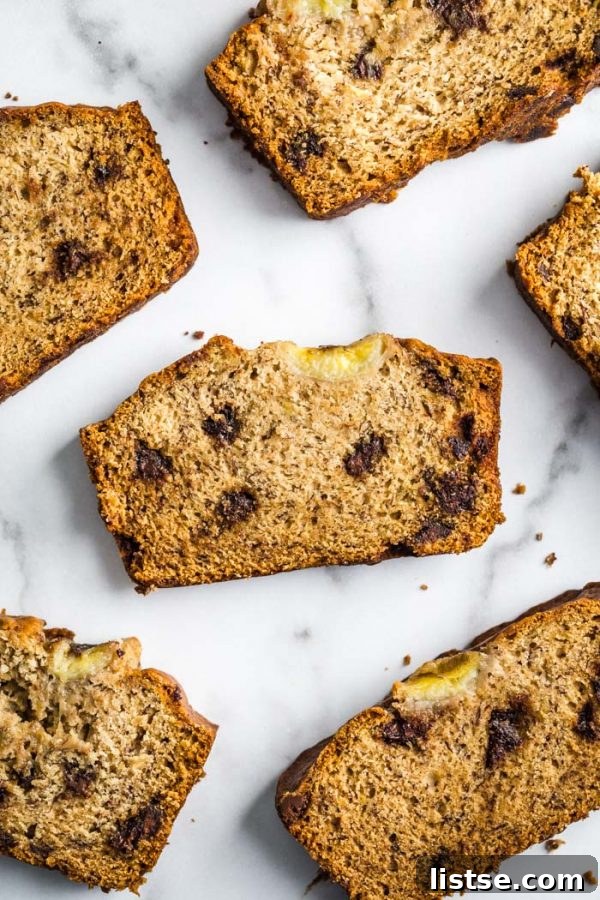 A perfectly baked loaf of vegan banana bread, golden brown and inviting, rests on a cooling rack, promising warmth and comfort.