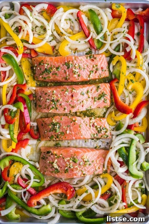 Close-up of Sheet Pan Garlic Lime Salmon cooking on a baking sheet with roasted vegetables.