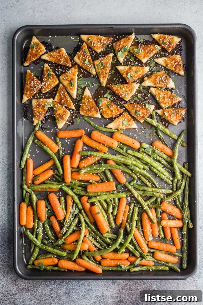 The finished sheet pan tofu and vegetable meal, garnished with fresh cilantro and sesame seeds