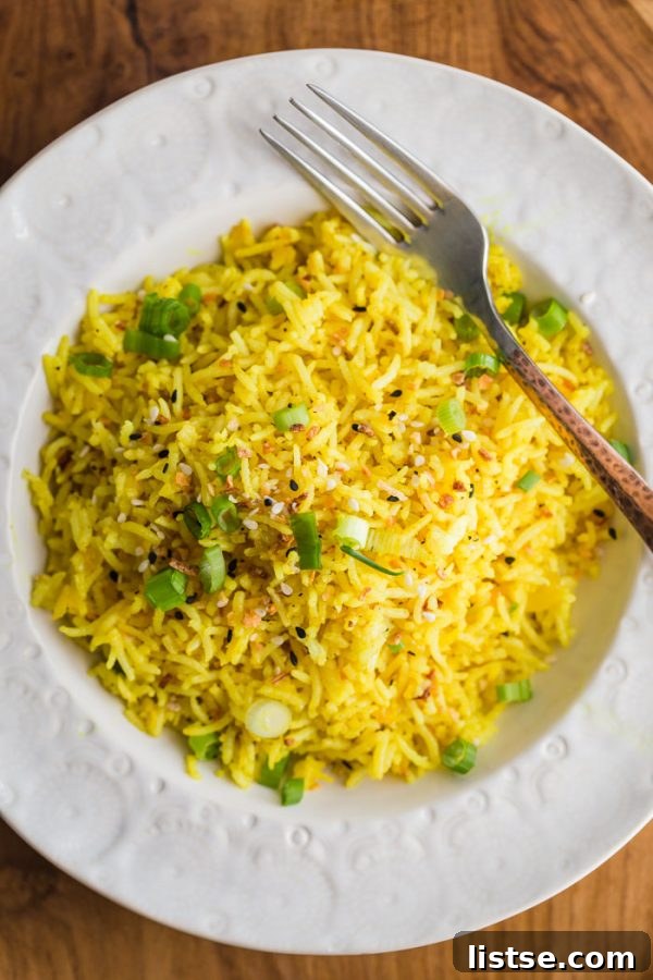 Golden Turmeric Lemon Basmati Rice in a bowl, garnished with fresh herbs