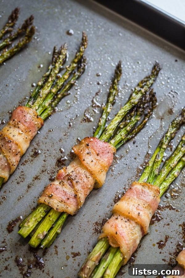 Baked bacon-wrapped asparagus arranged on a serving plate