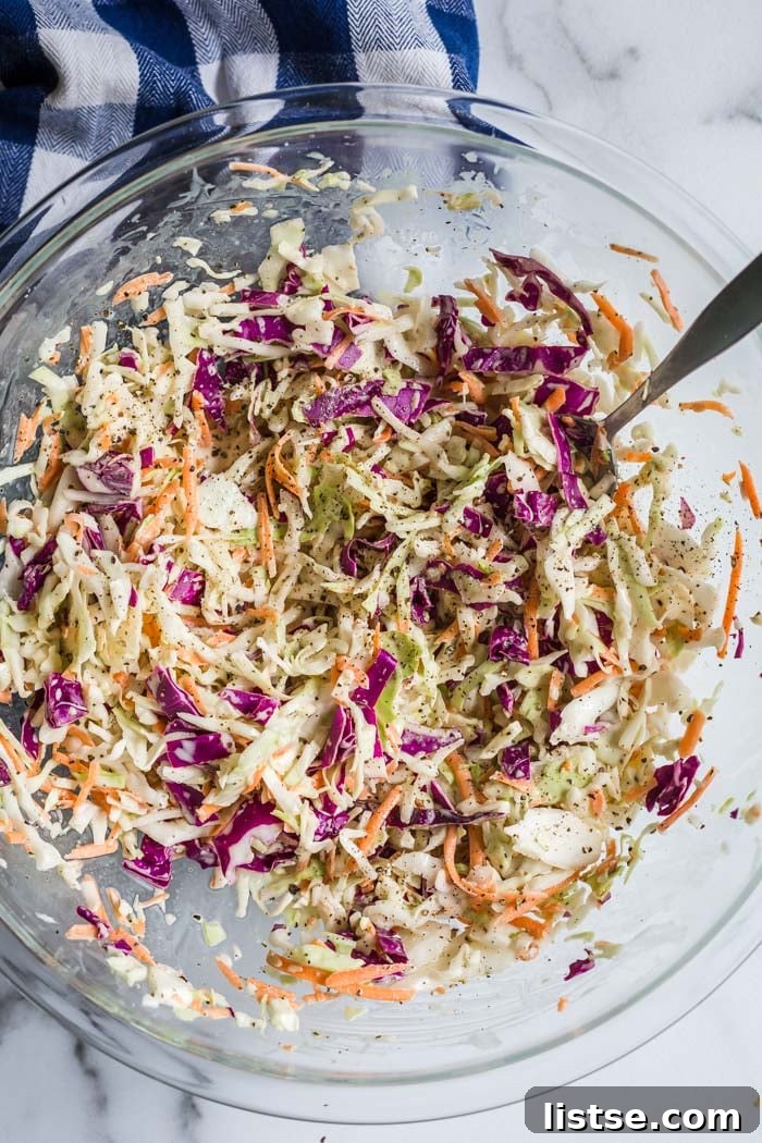 Effortless Creamy Vegan Coleslaw 4 Close-up of creamy vegan coleslaw dressing being mixed in a bowl, highlighting its smooth texture and fresh ingredients.