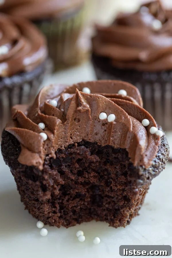Several fluffy vegan chocolate cupcakes cooling on a wire rack