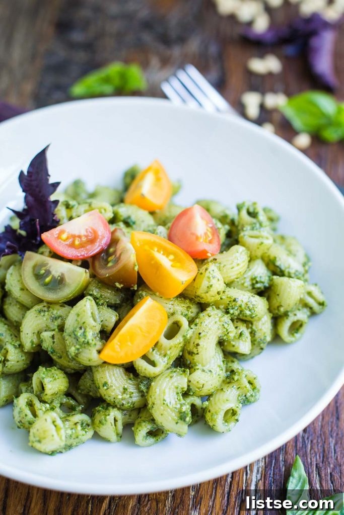 Bowl of fresh vegan pesto pasta with cherry tomatoes