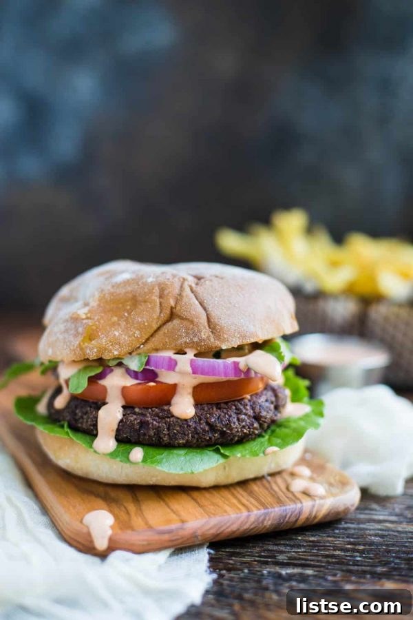 Grilled black bean and quinoa vegan burgers on buns with toppings