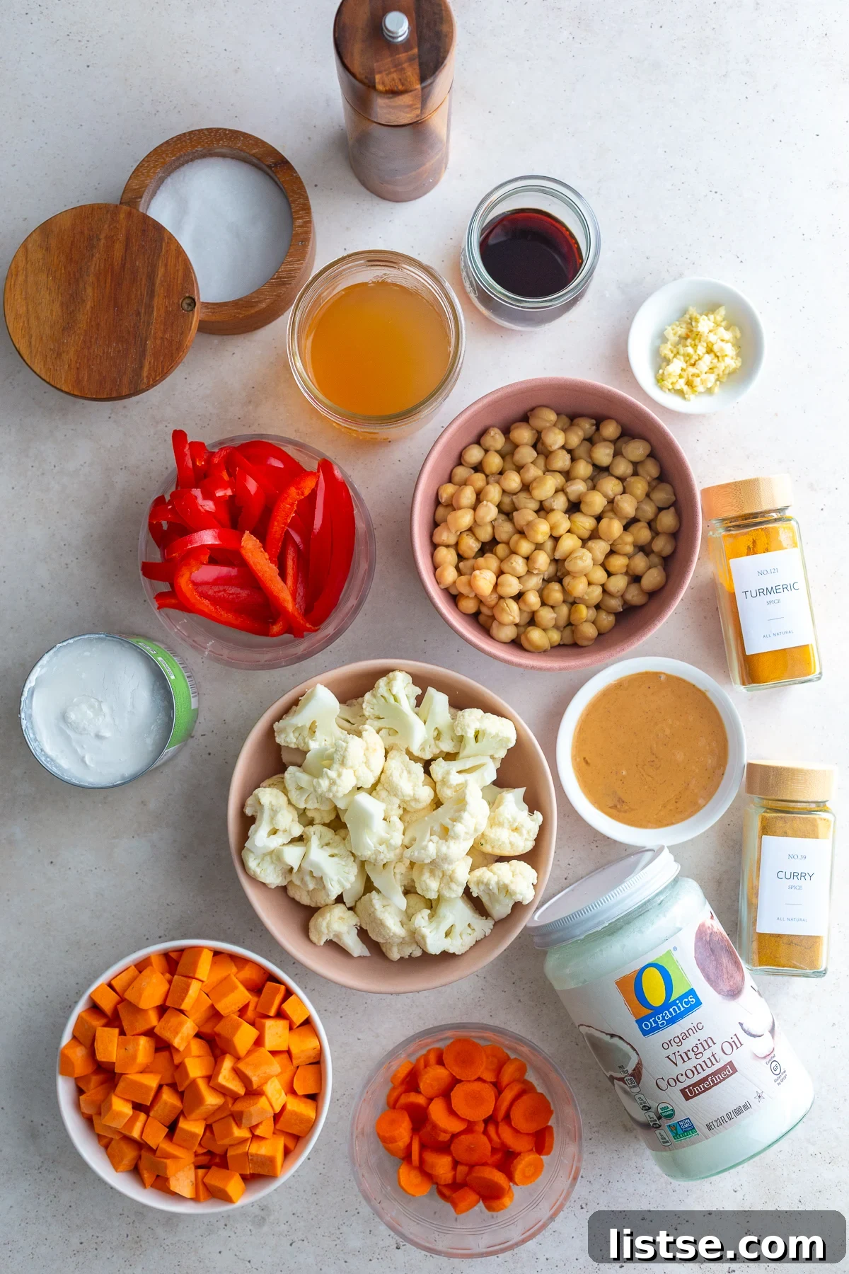 Golden Vegan Chickpea and Sweet Potato Coconut Curry 3 An array of fresh ingredients laid out for making sweet potato curry, including sweet potatoes, chickpeas, coconut milk, and spices.
