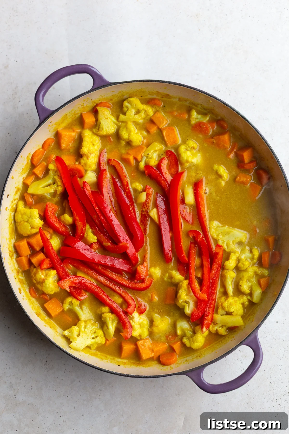 Golden Vegan Chickpea and Sweet Potato Coconut Curry 7 The curry sauce simmering with sweet potatoes, cauliflower, and carrots, developing its rich flavors.
