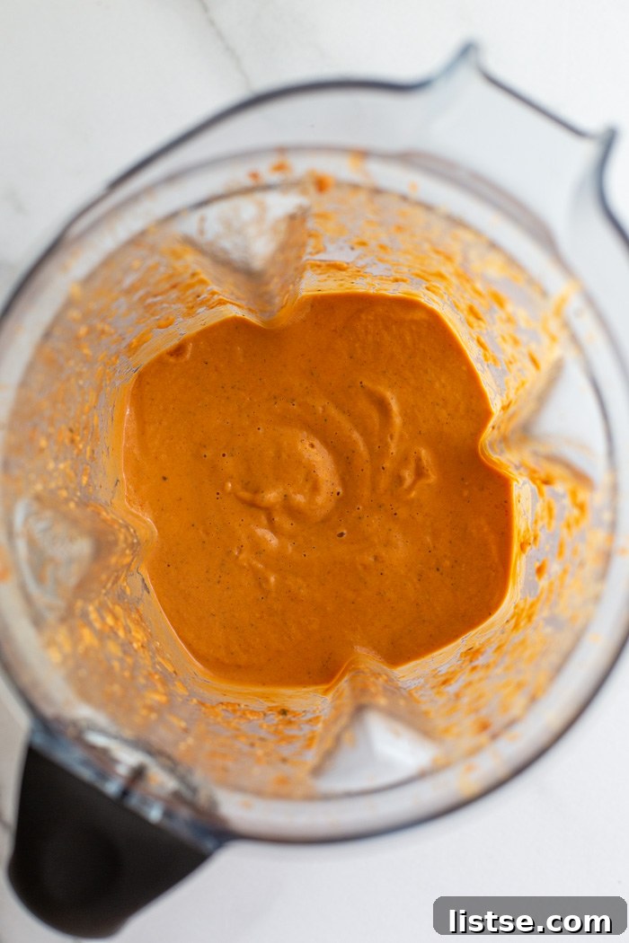 Tomato sauce ingredients blending in a high-speed blender.