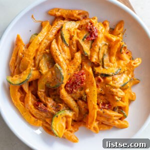 Creamy tomato pasta served in a white bowl, ready to be enjoyed.