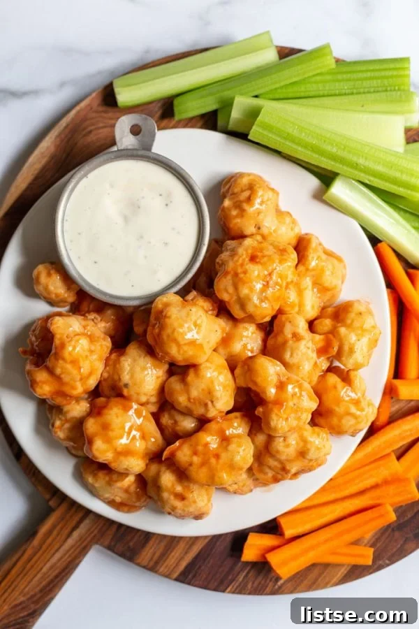 Close-up of baked cauliflower chicken wings, showing the crispy texture and rich buffalo sauce.