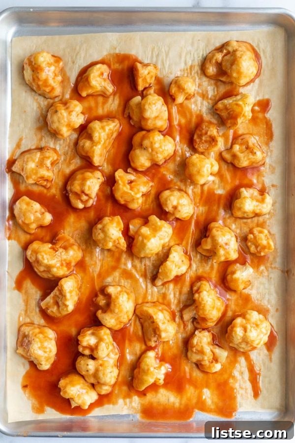 Batch of baked cauliflower wings on a baking sheet, fresh out of the oven.