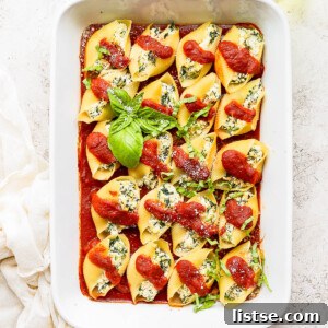 Vegan stuffed shells covered in sauce and garnished with basil.