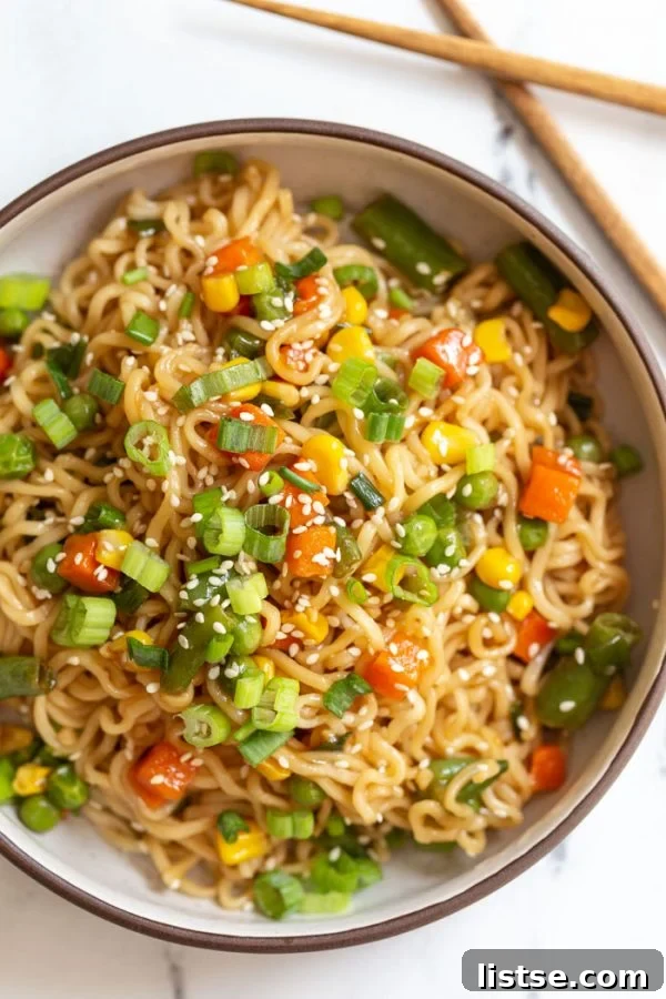 Vibrant and appetizing vegan ramen stir fry in a bowl, garnished with green onions and sesame seeds, ready to be enjoyed.